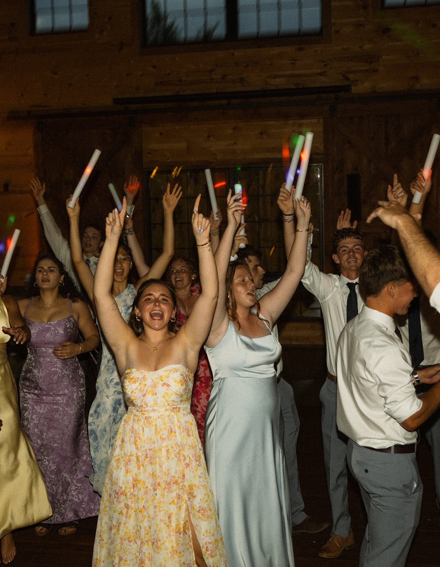 Wedding guests cheering with their hands in the air at The Barn at Bull Meadow