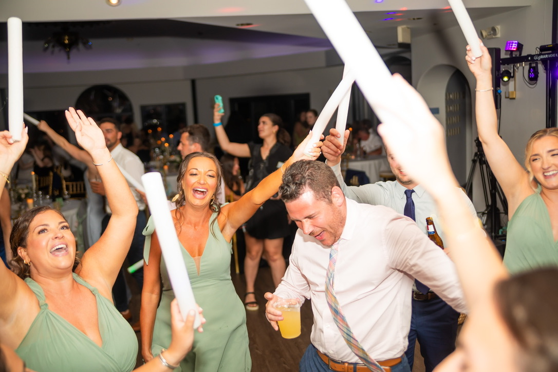 Wedding guests cheering with illuminated foam sticks