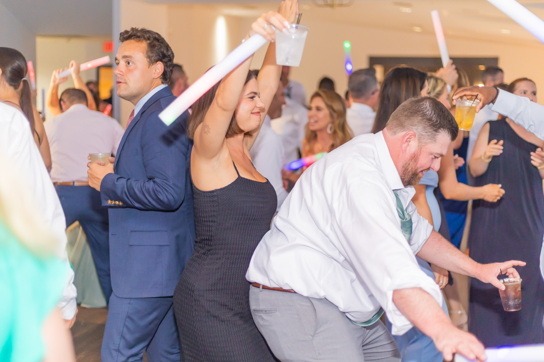 Wedding guests celebrating with illuminated foam sticks