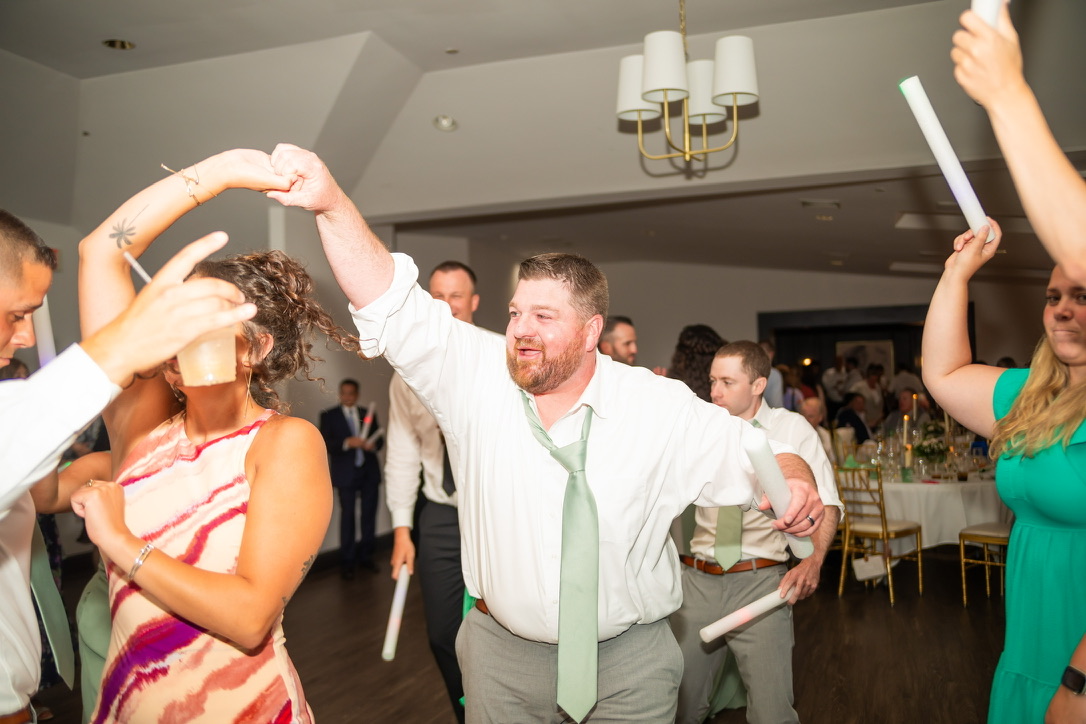 Wedding guest twirling his partner on the dance floor
